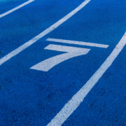 light blue number seven in the middle of a lane on a darker blue running track